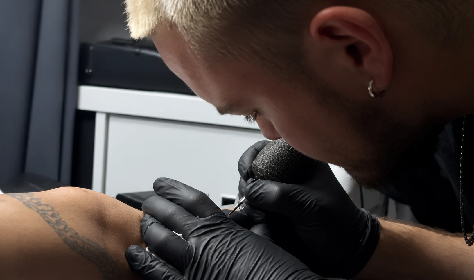 Matej tattooing, wearing black gloves
